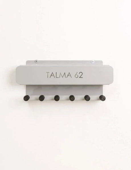  Wall-mounted HEGREN Pilates Stick Stand with 6 slots and 6 hooks for organized storage of Pilates sticks and accessories.