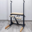  Side view of the HEGREN Pilates Chair TALMA 62CH showcasing its steel frame and beige upholstery.