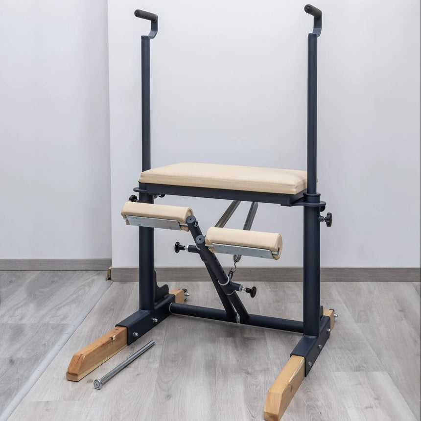  Side view of the HEGREN Pilates Chair TALMA 62CH showcasing its steel frame and beige upholstery.