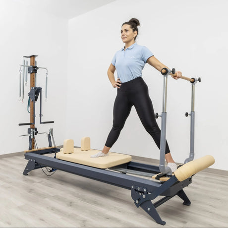 Side view of the HEGREN TALMA 62 Pilates Reformer showcasing its steel frame and beige upholstery.