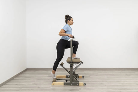  Side view of the HEGREN Pilates Chair TALMA 62CH showcasing its steel frame and beige upholstery.