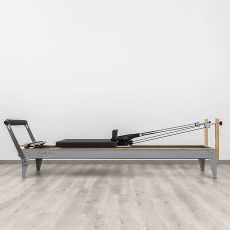  Side view of the HEGREN Pilates Reformer LEGATO 22 showcasing its steel frame and black upholstery.