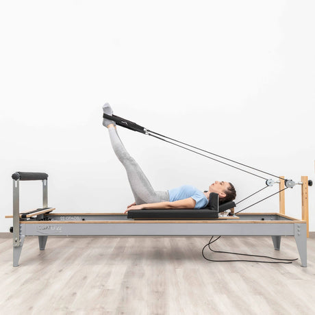  Side view of the HEGREN Pilates Reformer LEGATO 22 showcasing its steel frame and black upholstery.