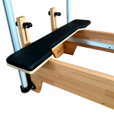 Wooden exercise bench with black seat pad on a white background