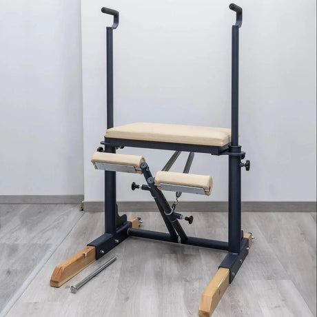  Side view of the HEGREN Pilates Chair TALMA 62CH showcasing its steel frame and beige upholstery.